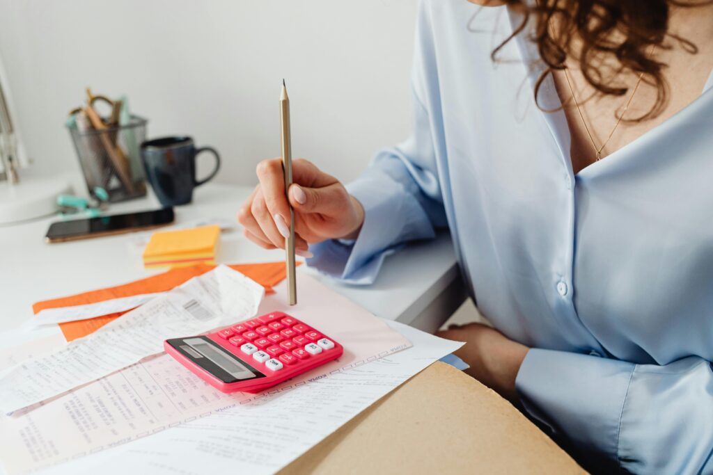 Woman reviewing multiple financial statements at a desk, symbolizing the importance of accurate records for small business decision-making.
